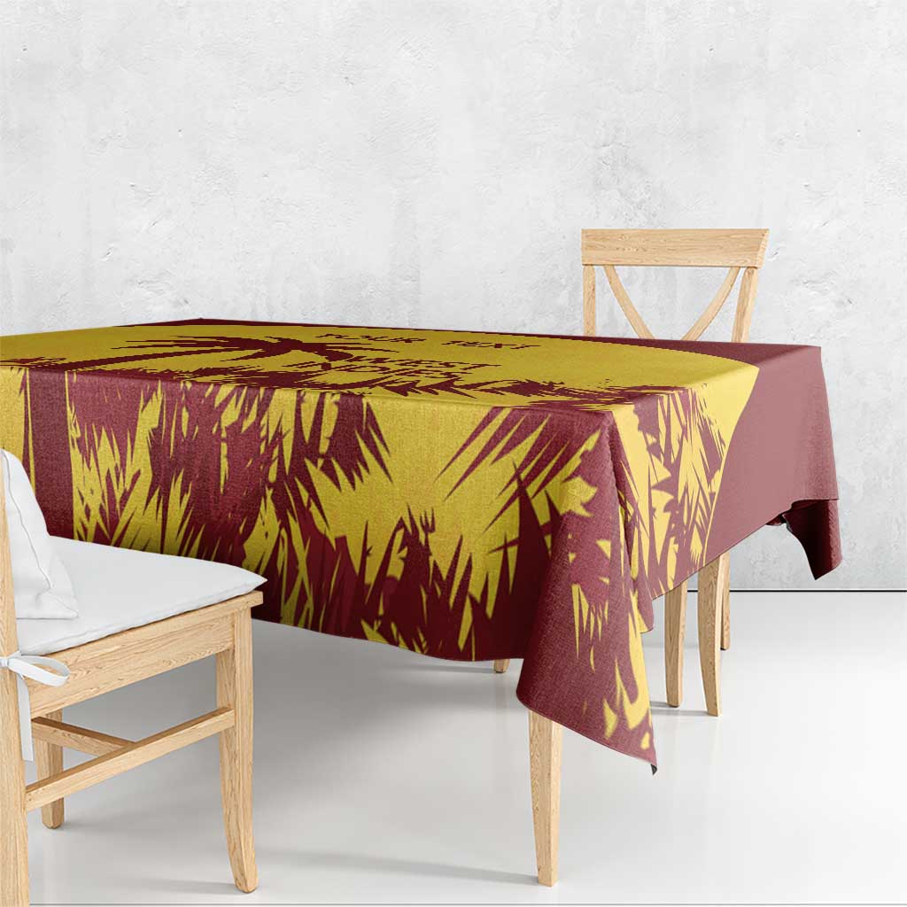 Gold and maroon palm-leaf tablecloth covering a dining table with overhang
