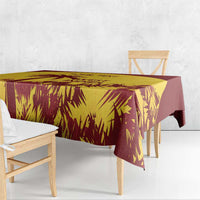 Gold and maroon palm-leaf tablecloth covering a dining table with overhang