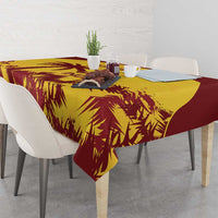 Gold and maroon palm-leaf tablecloth on dining table with place settings