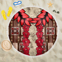 Round beach blanket with red hibiscus tapa-style pattern, floral garland center, fringe edge