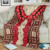 Samoa siapo blanket on armchair, red floral vines and brown geometric blocks with red petal border