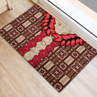 Brown rubber doormat with red hibiscus-style floral and white tapa blocks