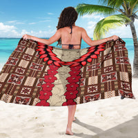 Brown sarong featuring a red flower vine center panel with geometric tapa pattern edges
