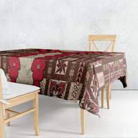 Corner view of brown tablecloth with red floral and geometric tapa pattern