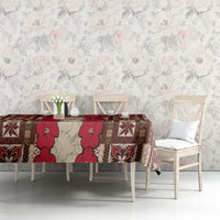 Tablecloth with red tapa floral and geometric motifs over table with chairs