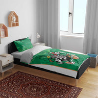 Green bedding set on bed with clover shamrock pattern and darts mascot dartboard graphic.