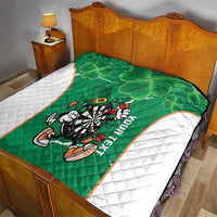 Green Ireland darts quilt on a bed with white side panels, clover pattern and mascot design