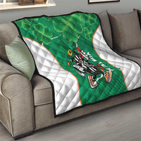 Green quilt on a sofa with white side panels, clover shamrock pattern and darts mascot