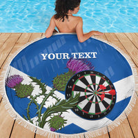 Round blue and white darts beach blanket featuring a dartboard and thistle graphic, fringed edge