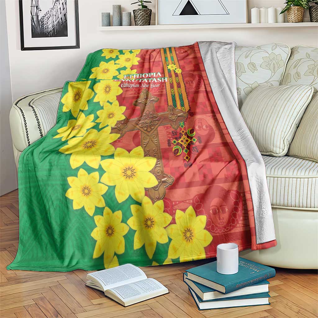 Red and green floral Ethiopian blanket draped over sofa with yellow blossoms and gold cross