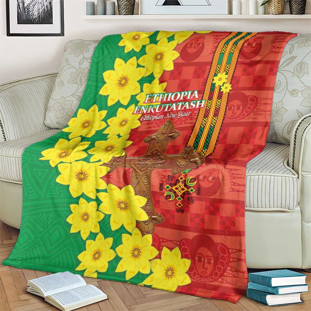 Red and green Ethiopian blanket laid on a bed with yellow blossoms and gold cross center