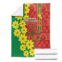 Red and green Ethiopian blanket with large yellow flower print and central gold cross motif