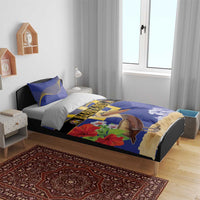 Blue bedding set with pelican and flowers print, gold trident emblem, matching pillowcases