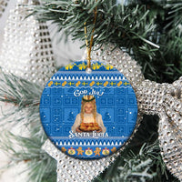 Blue round ceramic “God Jul!” “Santa Lucia” ornament hanging on pine branches.