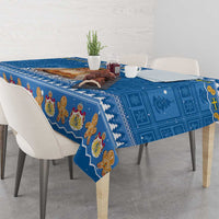 Blue holiday tablecloth with repeating gingerbread figures and snowy border on dining table