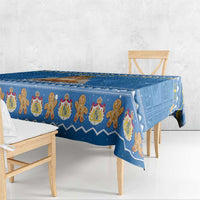 Blue holiday tablecloth draped over table edge with gingerbread figure motif