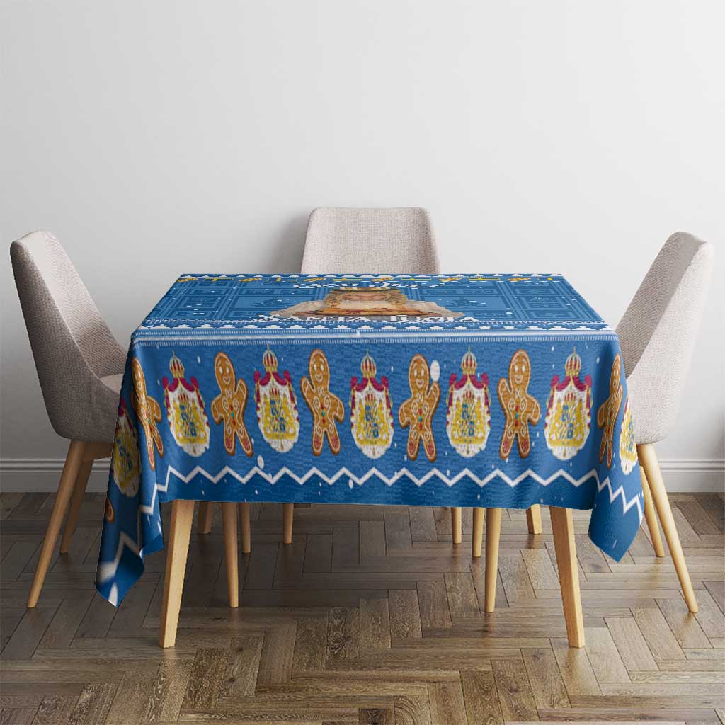 Blue holiday tablecloth covering dining table with repeating gingerbread figure design
