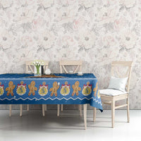 Blue holiday tablecloth with gingerbread figures and patterned border stripe on table
