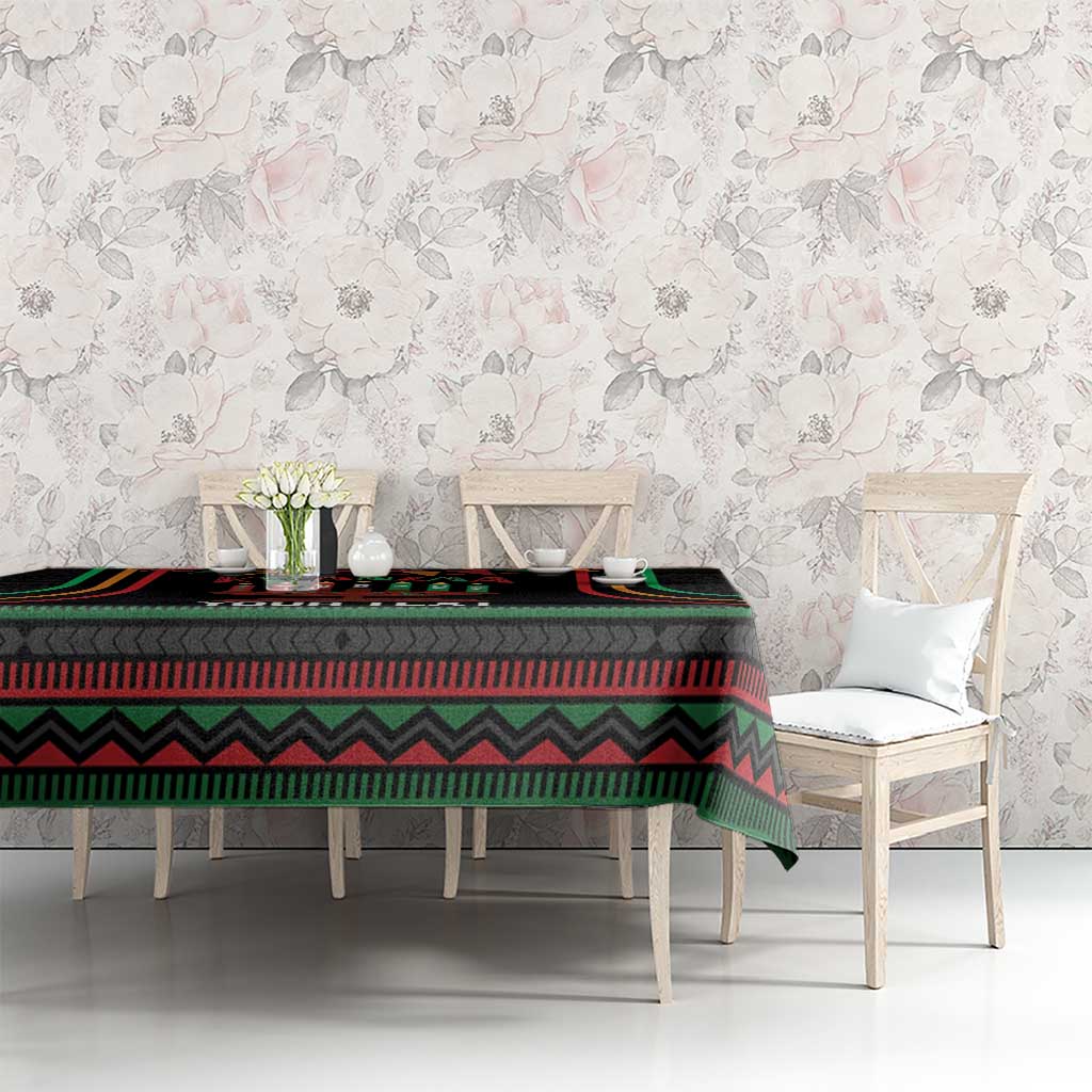 Black Kwanzaa tablecloth with colorful kinara stripe design on long dining table