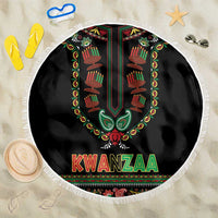 Round black Kwanzaa beach blanket with fringed edge, candle graphic, and “KWANZAA” text