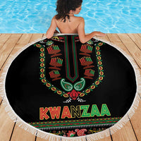 Round black Kwanzaa beach blanket with fringed border, green-red candle pattern and “KWANZAA”