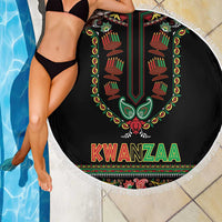 Round black Kwanzaa beach blanket with fringed border, candle artwork and “KWANZAA” text