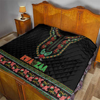 Black quilt on bed featuring colorful dashiki neckline, KWANZAA text, and patterned border