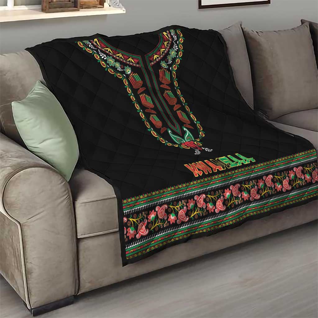 Black quilt on gray sofa showing dashiki motif, KWANZAA lettering, and floral edge trim
