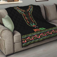 Black quilt on gray sofa showing dashiki motif, KWANZAA lettering, and floral edge trim