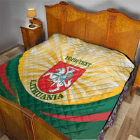 Lithuania quilt blanket on bed, yellow and white quilted diamonds with green and red bands, crest
