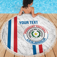 Paraguay football beach blanket, white round fringed towel with crest and tricolor stripes on deck.