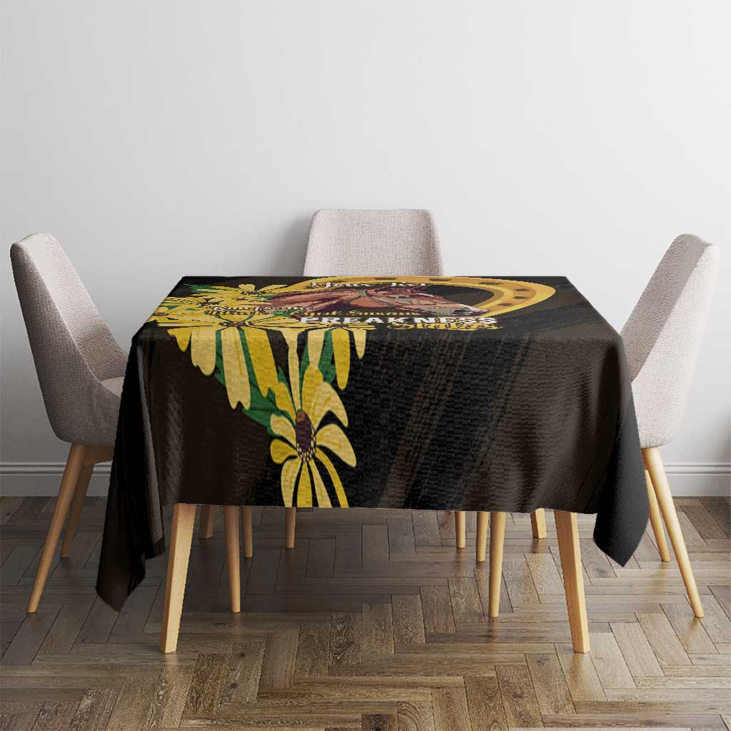 Black tablecloth with yellow flowers and horse artwork centered on dining table