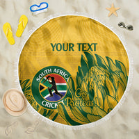Yellow round beach blanket with white fringed edge, South Africa cricket emblem and palm leaves