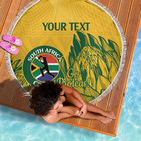 Yellow round beach blanket with white fringed edge, custom text and cricket emblem with palm leaves