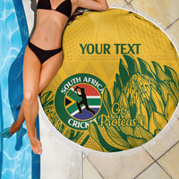 Yellow round beach blanket with white fringed edge, custom text, cricket emblem and palm leaves