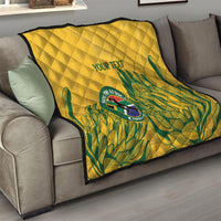 Yellow quilt draped on couch with diamond quilting, green tropical design, and “YOUR TEXT”.