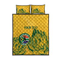 Yellow quilt bed set with two square pillows; green palm print and South Africa Cricket logo