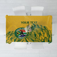 Yellow tablecloth with green tropical leaf pattern and circular cricket emblem design