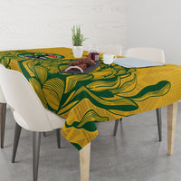 Yellow tablecloth with green leaf pattern covering dining table with chairs