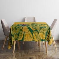 Yellow tablecloth with green tropical leaf print on square dining table
