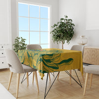 Yellow tablecloth with green leaf pattern on dining table in a bright room