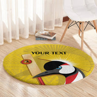 Round yellow carpet with crowned crane graphic and 'YOUR TEXT' on center