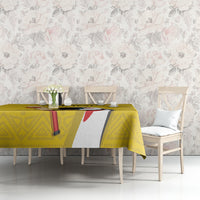 Yellow custom tablecloth with geometric pattern and central bird graphic on a dining table