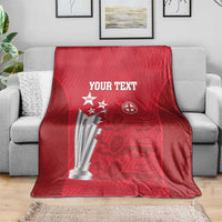 Red cricket blanket on gray sofa with trophy artwork and 'YOUR TEXT'