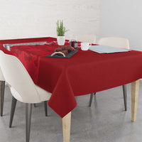 Red tablecloth with cricket-themed print across dining table, side overhang
