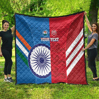 Cricket quilt blanket spread outdoors, blue and red flag-style design with emblems