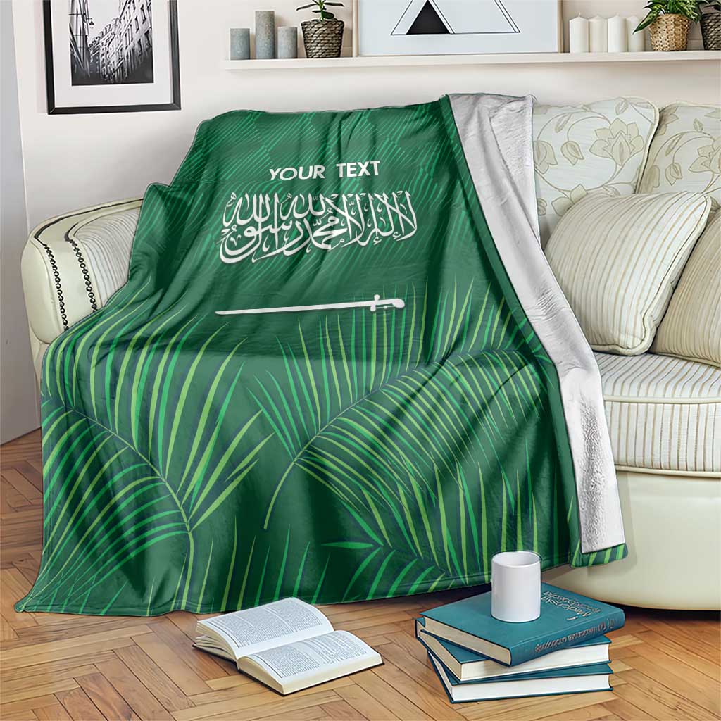 Green football blanket draped on armchair, palm leaf pattern with "YOUR TEXT" and Arabic text