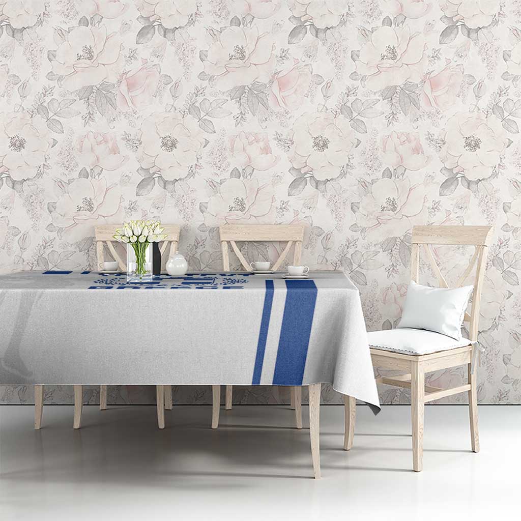 White tablecloth featuring blue Greece stripes and crest on rectangular dining table
