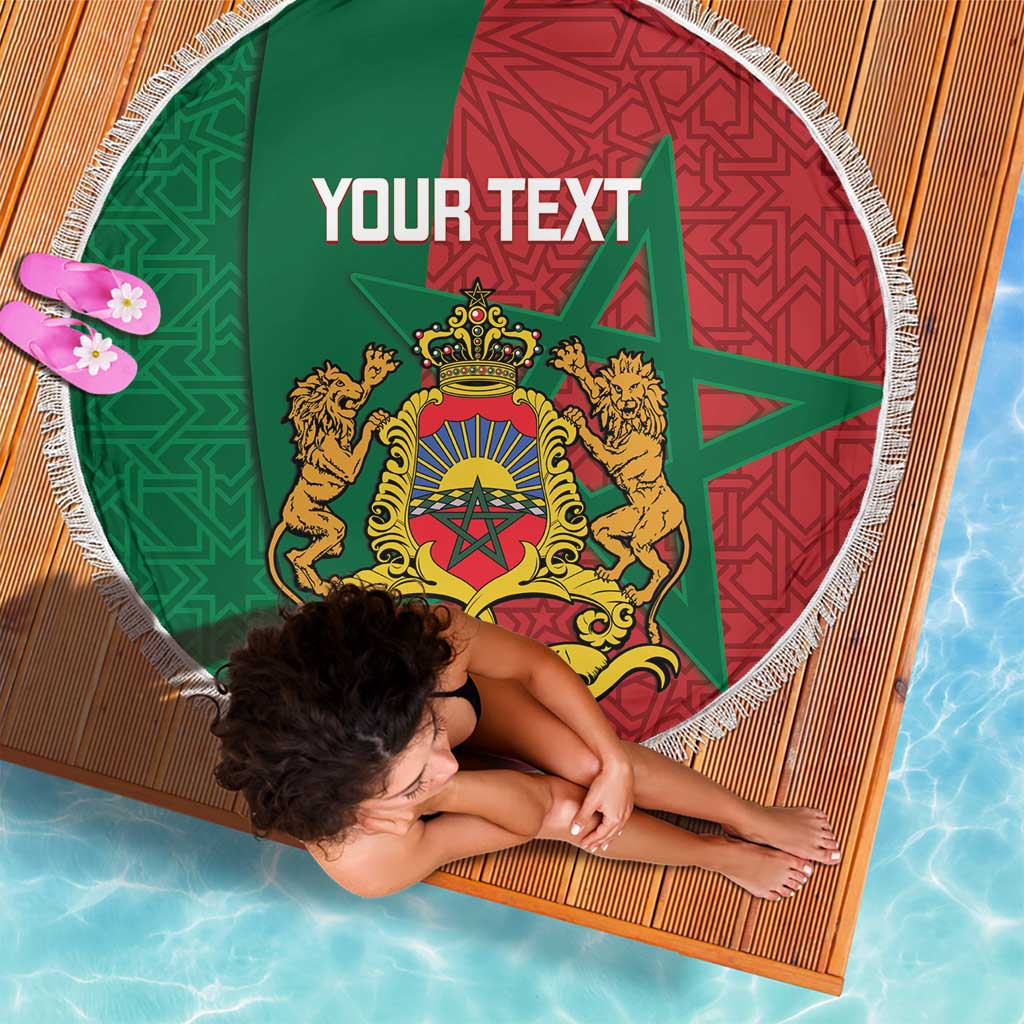 Round beach blanket with fringed border, green and red Moroccan crest design