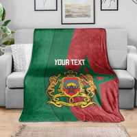 Personalized Moroccan blanket on sofa: green and red pattern with crest graphic